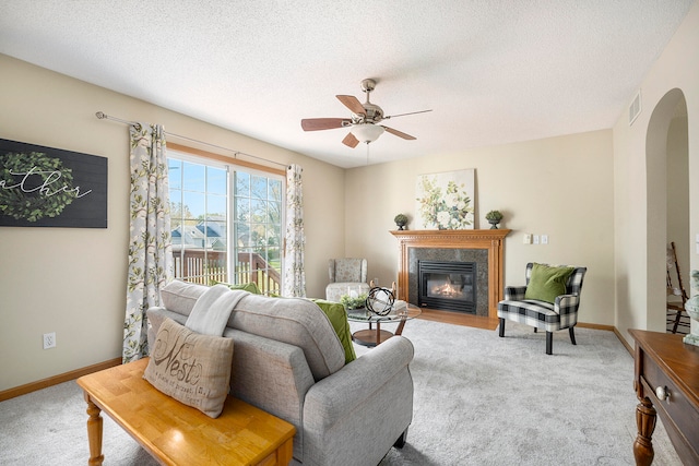 living room featuring ceiling fan, light colored carpet, and a textured ceiling