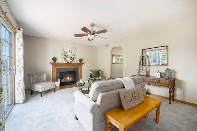 living room featuring a textured ceiling, light colored carpet, and ceiling fan