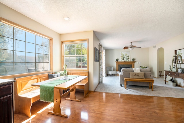 dining area with ceiling fan, wood-type flooring, and a textured ceiling