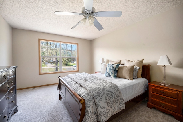 carpeted bedroom with ceiling fan and a textured ceiling