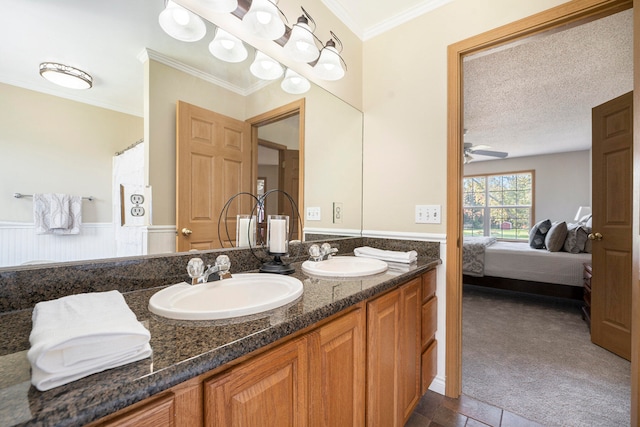 bathroom with ceiling fan, ornamental molding, a textured ceiling, and vanity