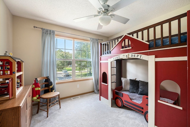 bedroom featuring carpet flooring, ceiling fan, and a textured ceiling