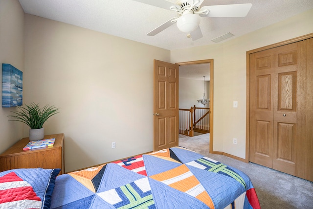 carpeted bedroom featuring ceiling fan, a textured ceiling, and a closet