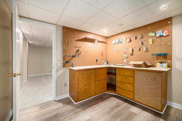 interior space featuring light wood-type flooring and a drop ceiling