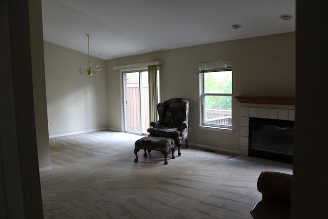 sitting room with a fireplace, light colored carpet, a chandelier, and a healthy amount of sunlight