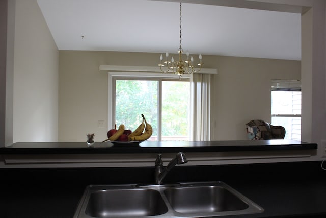 kitchen featuring pendant lighting, sink, and a chandelier