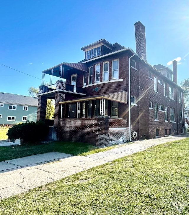 view of front of property featuring a balcony and a front lawn