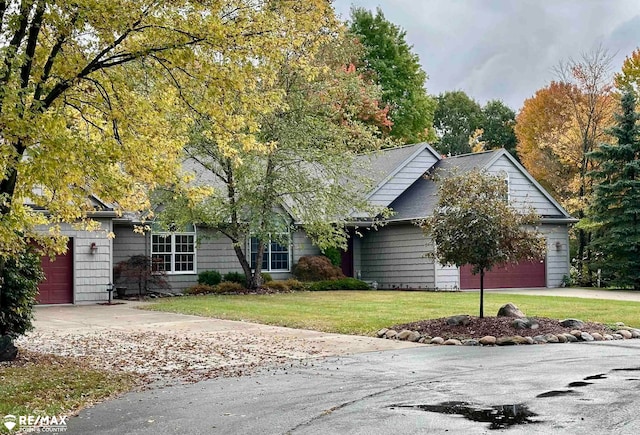 obstructed view of property with a front yard and a garage