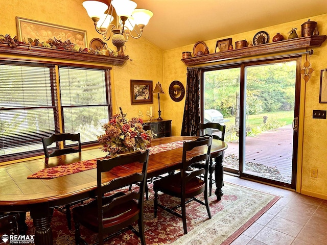 dining room featuring lofted ceiling, tile patterned floors, and a notable chandelier