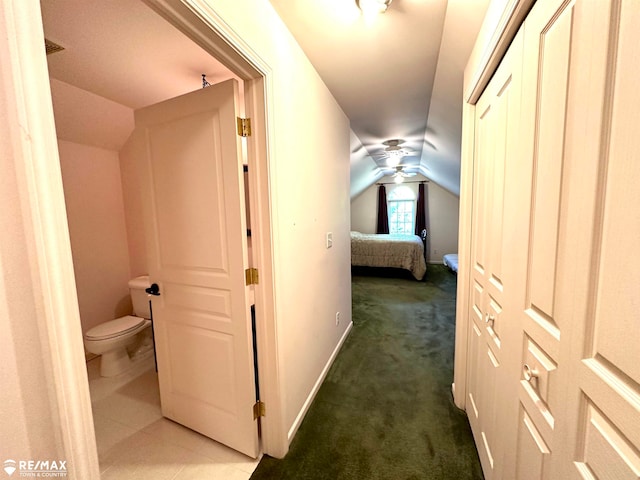 hallway with dark carpet and vaulted ceiling