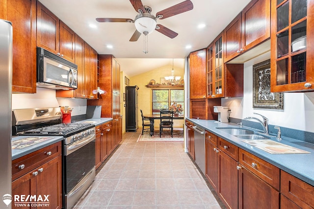 kitchen with ceiling fan with notable chandelier, lofted ceiling, stainless steel appliances, and light tile patterned floors