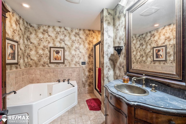 bathroom with tile patterned flooring, vanity, and a bath