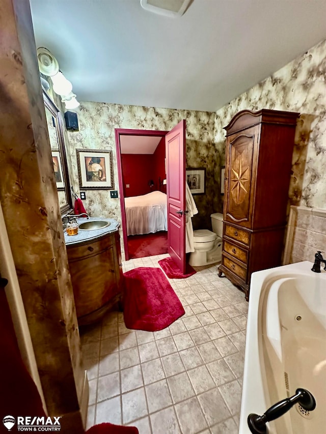 bathroom featuring tile patterned flooring, vanity, and toilet