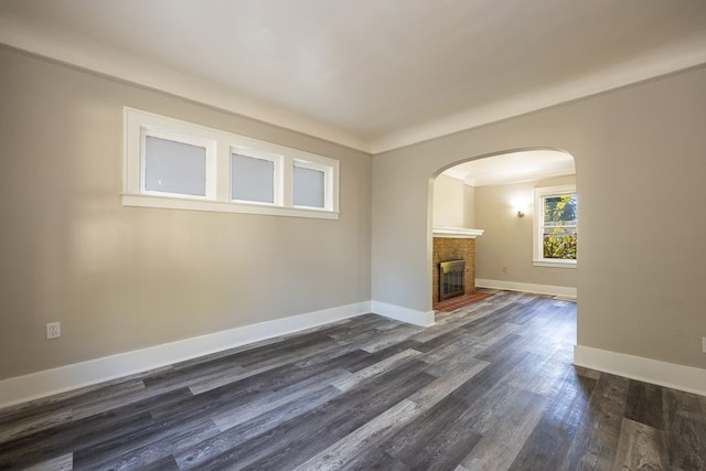 unfurnished living room with ornamental molding and dark wood-type flooring