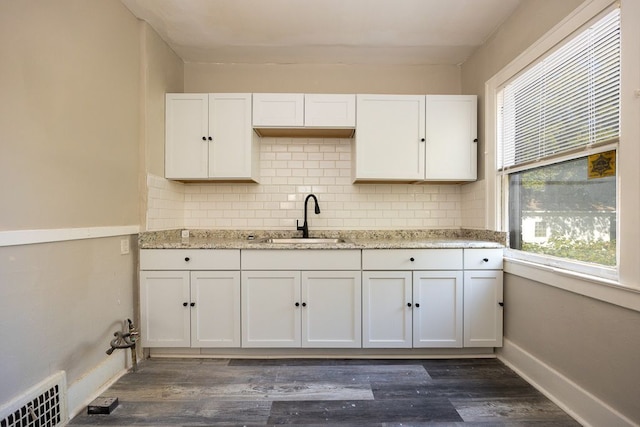 kitchen with dark hardwood / wood-style flooring, white cabinetry, and sink