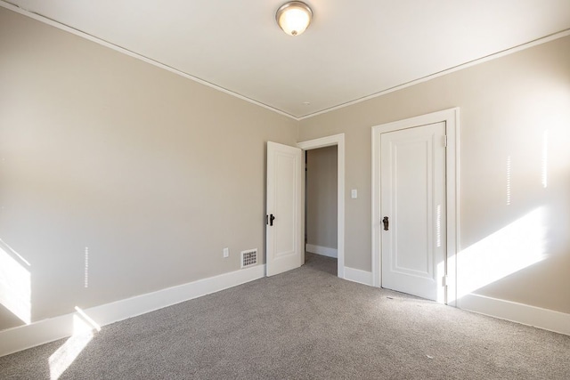 spare room featuring carpet flooring and crown molding