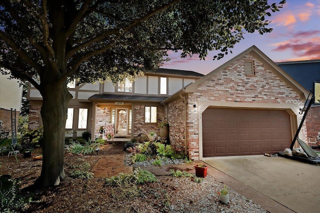 view of front of house with driveway, brick siding, and an attached garage