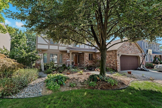 view of front of property with a garage, driveway, and brick siding