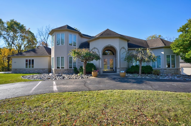 view of front of home with french doors and a front lawn