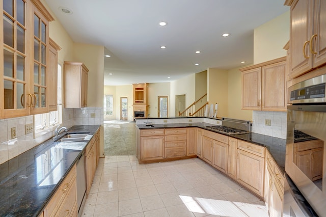 kitchen featuring sink, light brown cabinets, stainless steel appliances, backsplash, and kitchen peninsula