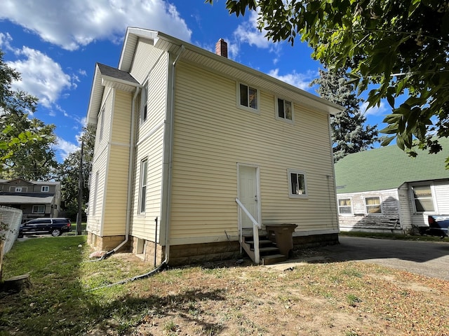 back of property featuring a yard