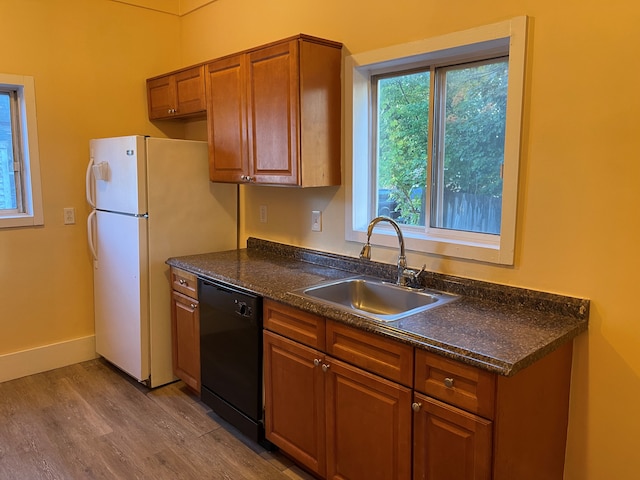 kitchen featuring white refrigerator, dishwasher, light hardwood / wood-style floors, and sink