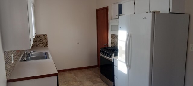 kitchen with white cabinets, decorative backsplash, white appliances, and sink