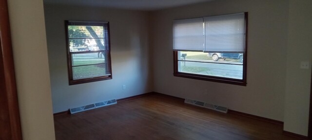 unfurnished room with dark hardwood / wood-style flooring