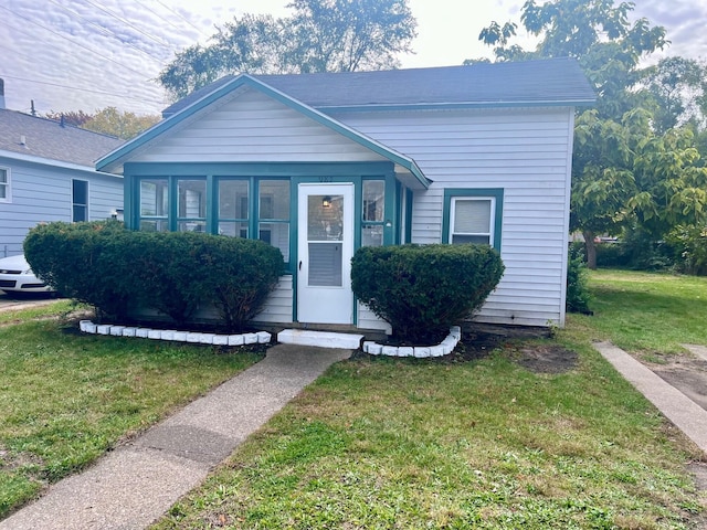 view of front of property with a sunroom and a front yard