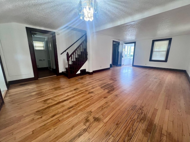 unfurnished living room with hardwood / wood-style flooring and a textured ceiling