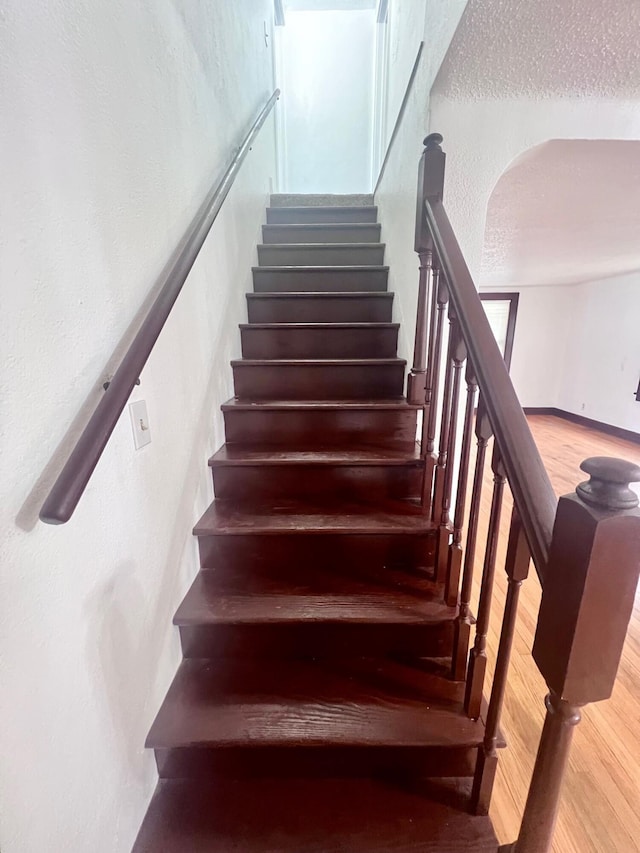 stairs featuring hardwood / wood-style floors