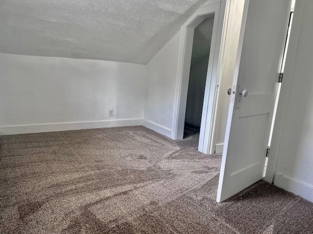 bonus room featuring carpet flooring, lofted ceiling, and a textured ceiling