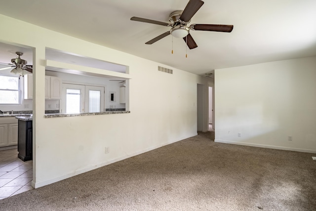 interior space with ceiling fan and light carpet