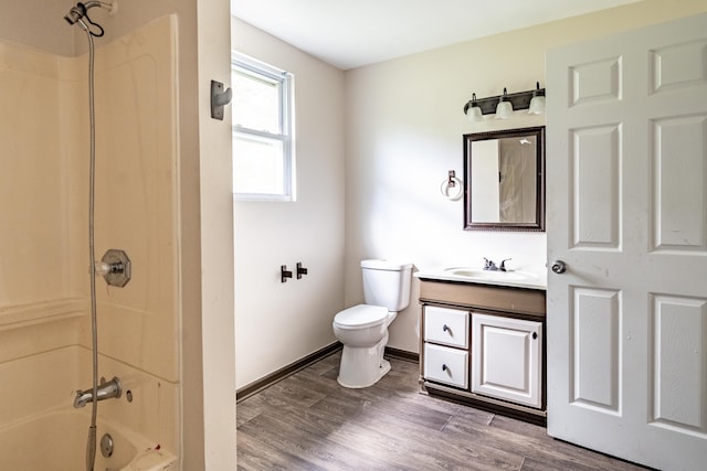 full bathroom featuring bathing tub / shower combination, hardwood / wood-style floors, vanity, and toilet