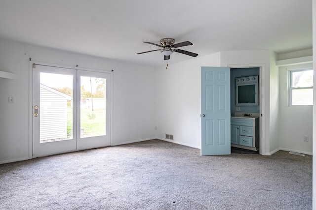 unfurnished room featuring carpet, ceiling fan, and a healthy amount of sunlight