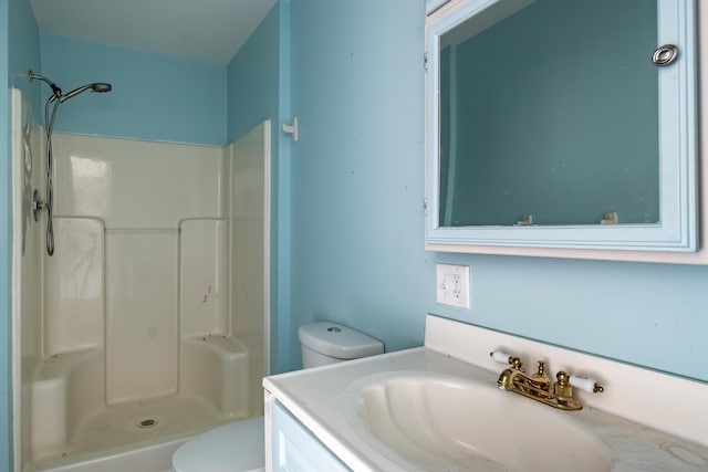 bathroom featuring toilet, vanity, and walk in shower