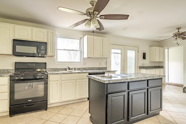 kitchen with gray cabinetry, sink, a center island, light tile patterned floors, and black appliances