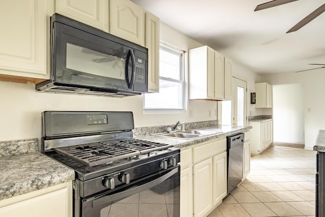 kitchen featuring black appliances, light tile patterned flooring, sink, and cream cabinets