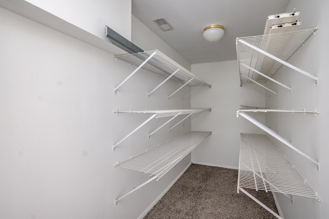 spacious closet featuring dark carpet