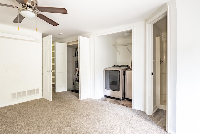 clothes washing area featuring washer and clothes dryer, ceiling fan, and light colored carpet