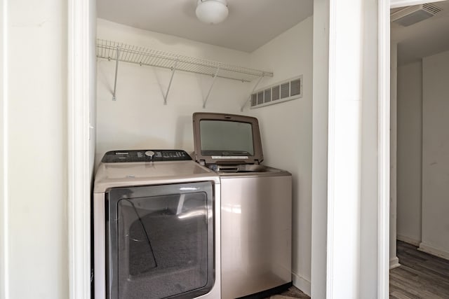 washroom with washer and clothes dryer and dark wood-type flooring