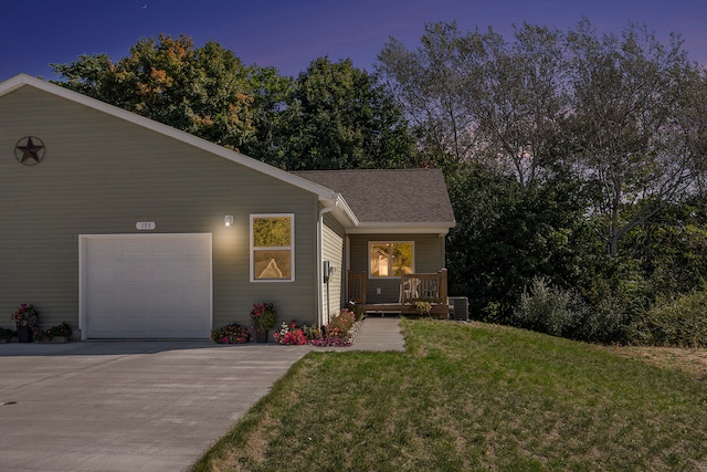 view of front of home with a lawn, a garage, and central air condition unit