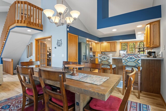 11826 Ridge View Dr, Rapid City, MI 49676 - living area featuring high vaulted ceiling, a chandelier, and light wood finished floors