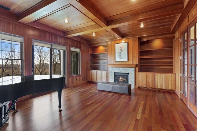 4559 Trails End Path, Saint Joseph, MI 49085 - living area featuring wood ceiling with exposed beams, wooden walls, built in features, wood finished floors, and a lit fireplace