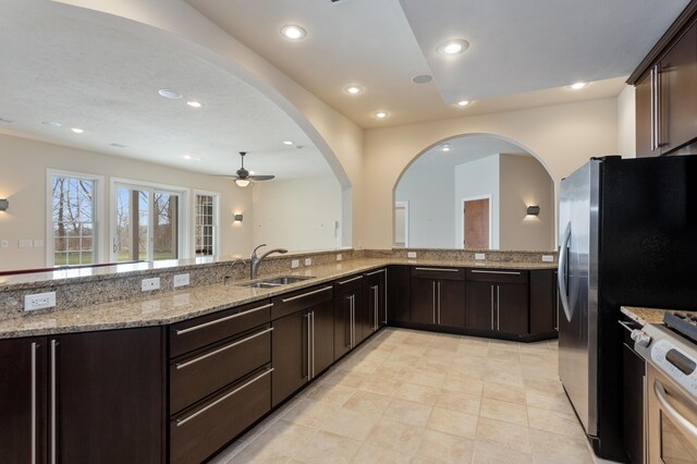 4559 Trails End Path, Saint Joseph, MI 49085 - kitchen featuring a sink, ceiling fan, dark brown cabinetry, stainless steel stove, and light stone counters