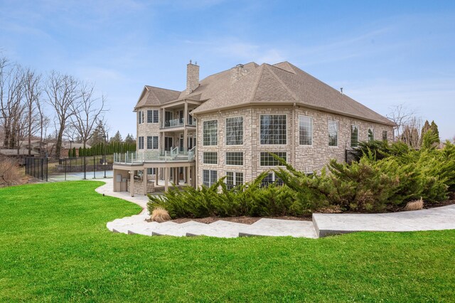 4559 Trails End Path, Saint Joseph, MI 49085 - rear view of property with a chimney, a balcony, stone siding, and a shingled roof