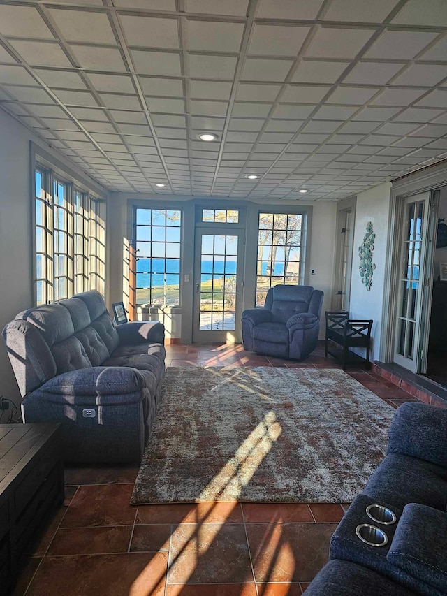 living room featuring a water view and dark tile patterned flooring