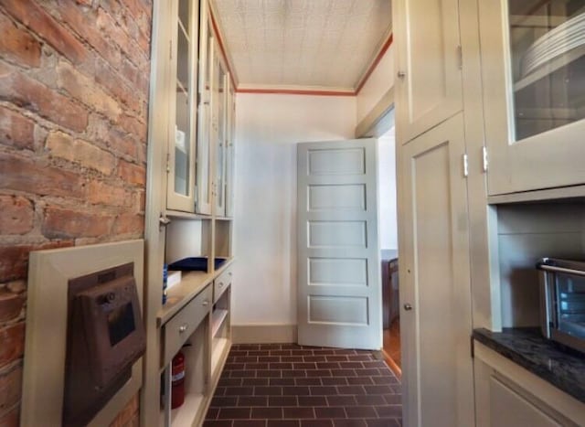 interior space with crown molding and brick wall