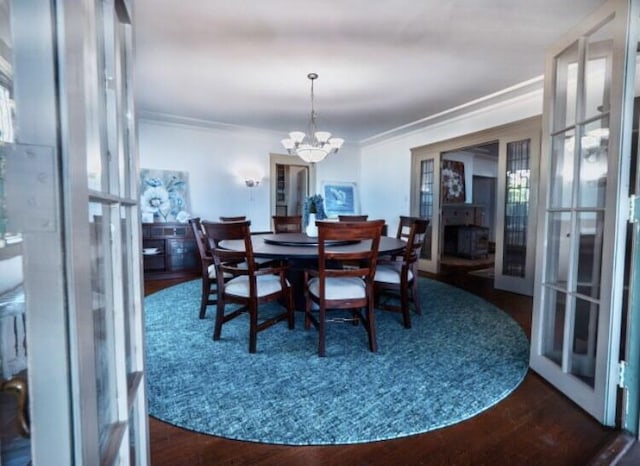 dining room with dark hardwood / wood-style flooring, crown molding, french doors, and a chandelier