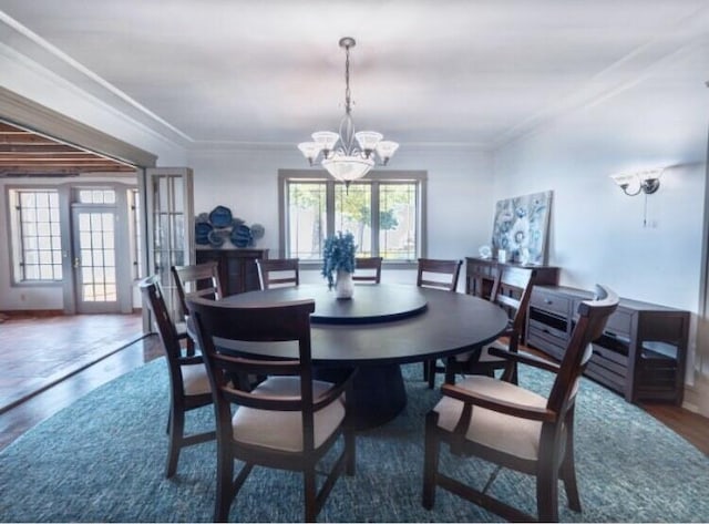 dining area with a wealth of natural light, french doors, ornamental molding, and a notable chandelier